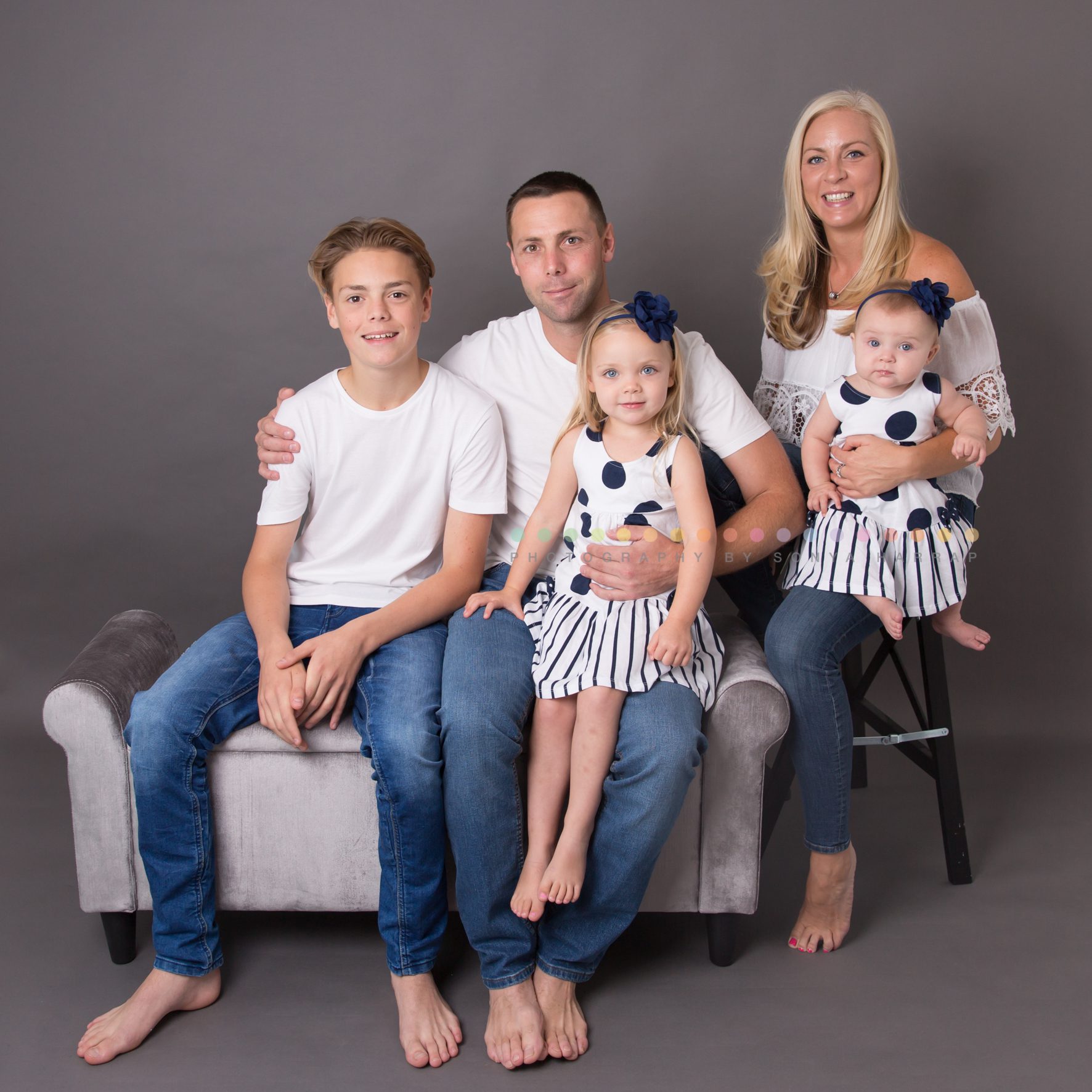 family photos with two girls and one son with a grey backdrop and white colour palette by Sonya Harrap Photography