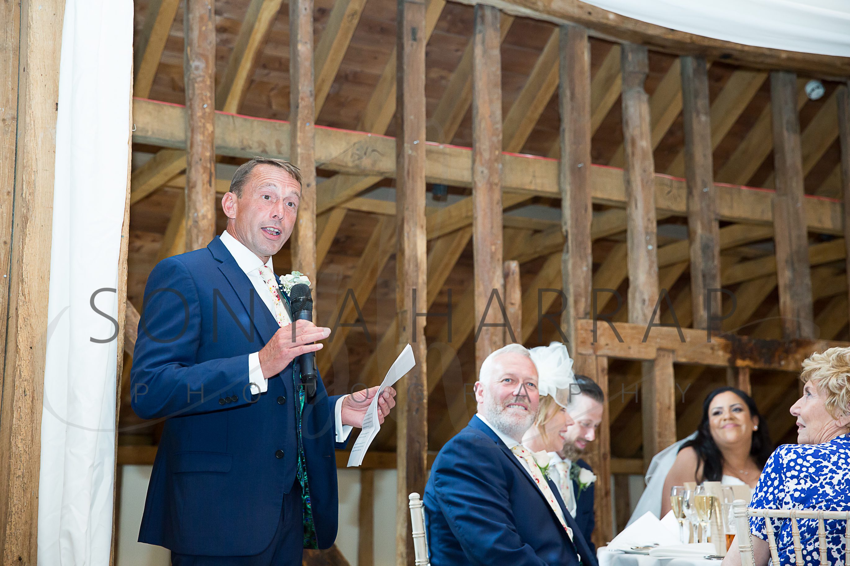 Tewinbury farm hotel wedding photograph of bride and groom by Sonya Harrap photographer father of the bride speech in blue suit
