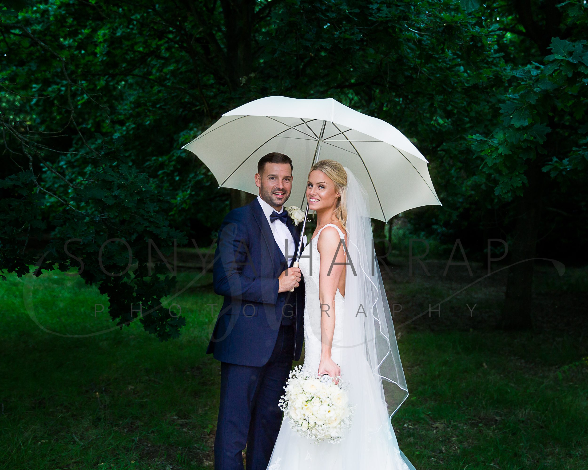 wedding photography by Sonya Harrap Hertfordshire church service of bride and groom and photos on theobald park herts under an umbrella