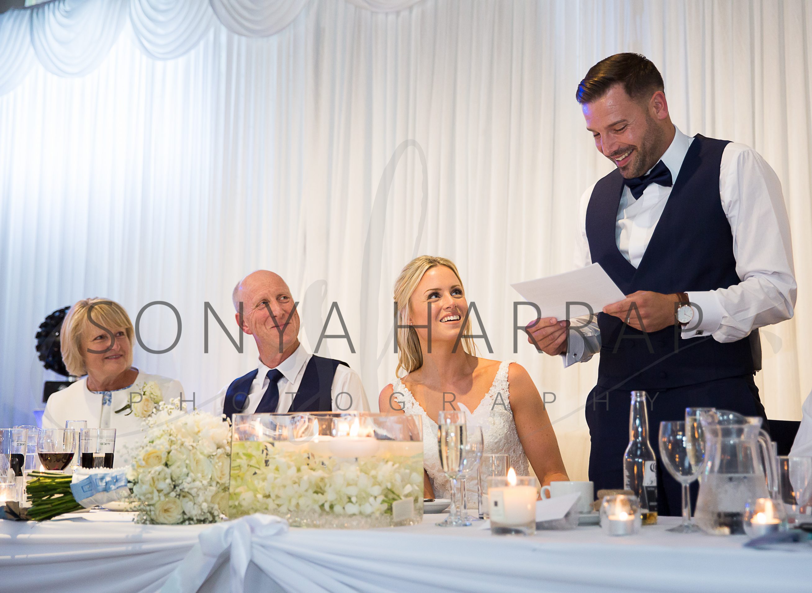 Bride and groom in confetti wedding Photography during grooms speech photography by Sonia Harrap
