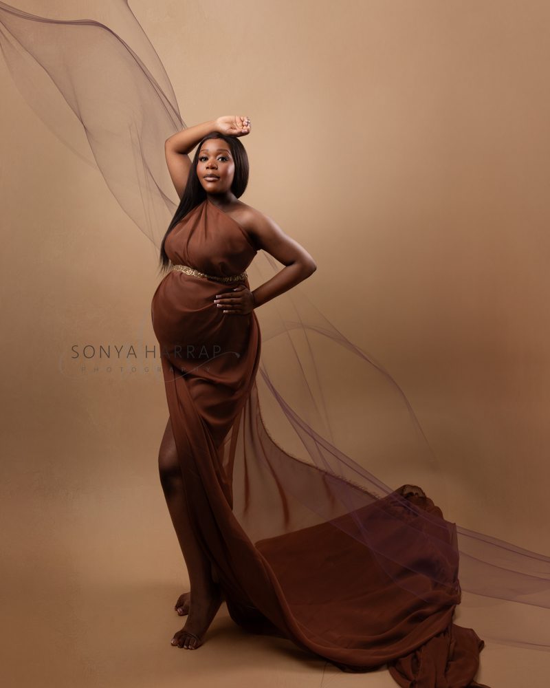 maternity pregnancy photoshoot woman in green and blue fabric dress brown dress fabric- modest maternity photoshoot