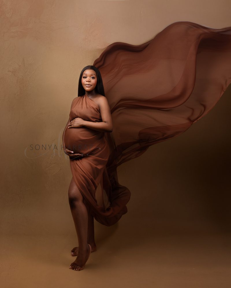 maternity pregnancy photoshoot woman in green and blue fabric dress brown dress fabric- modest maternity photoshoot