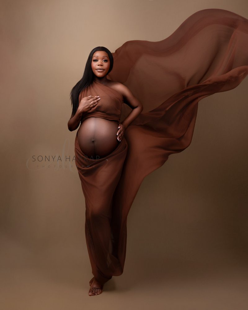 maternity pregnancy photoshoot woman in green and blue fabric dress brown dress fabric