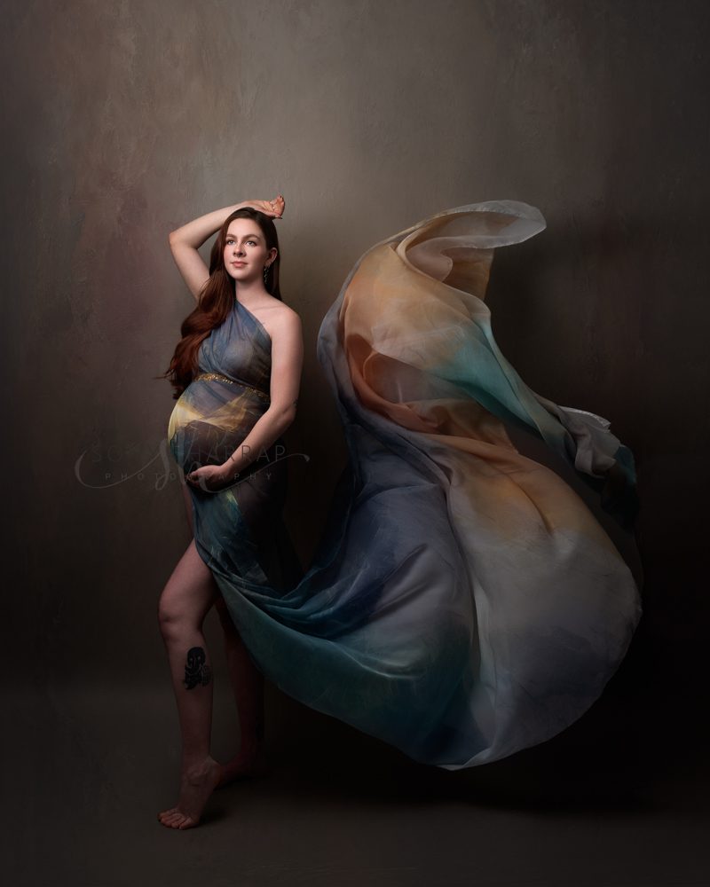 maternity pregnancy photoshoot woman in green and blue fabric dress brown dress fabric