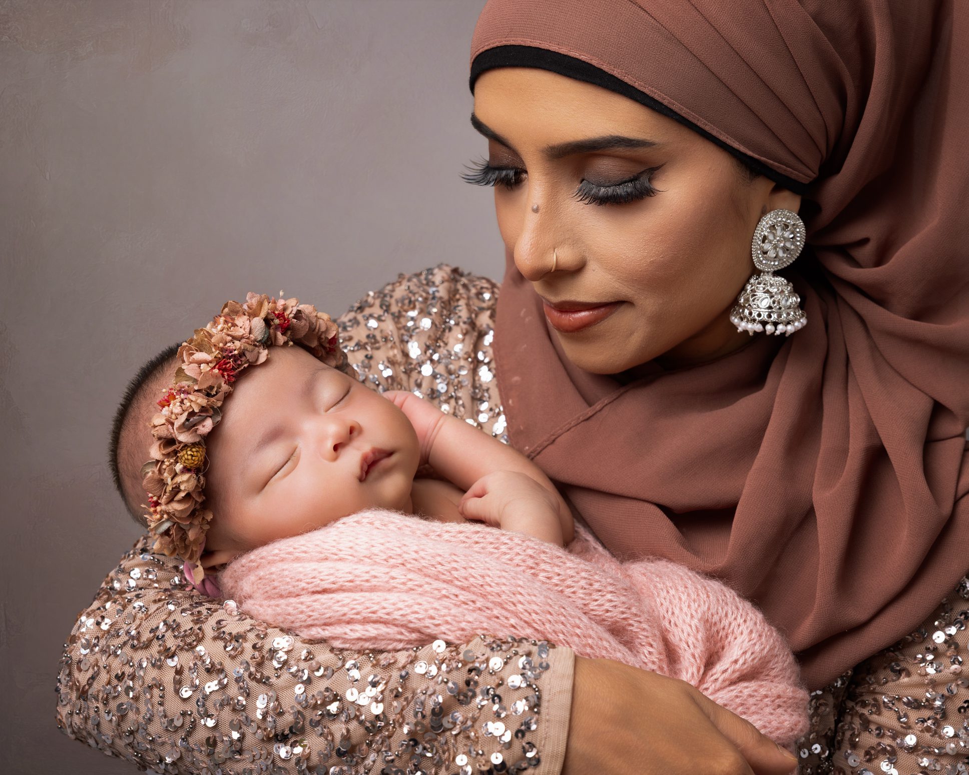 Mother holding her newborn baby during a natural family photography session.