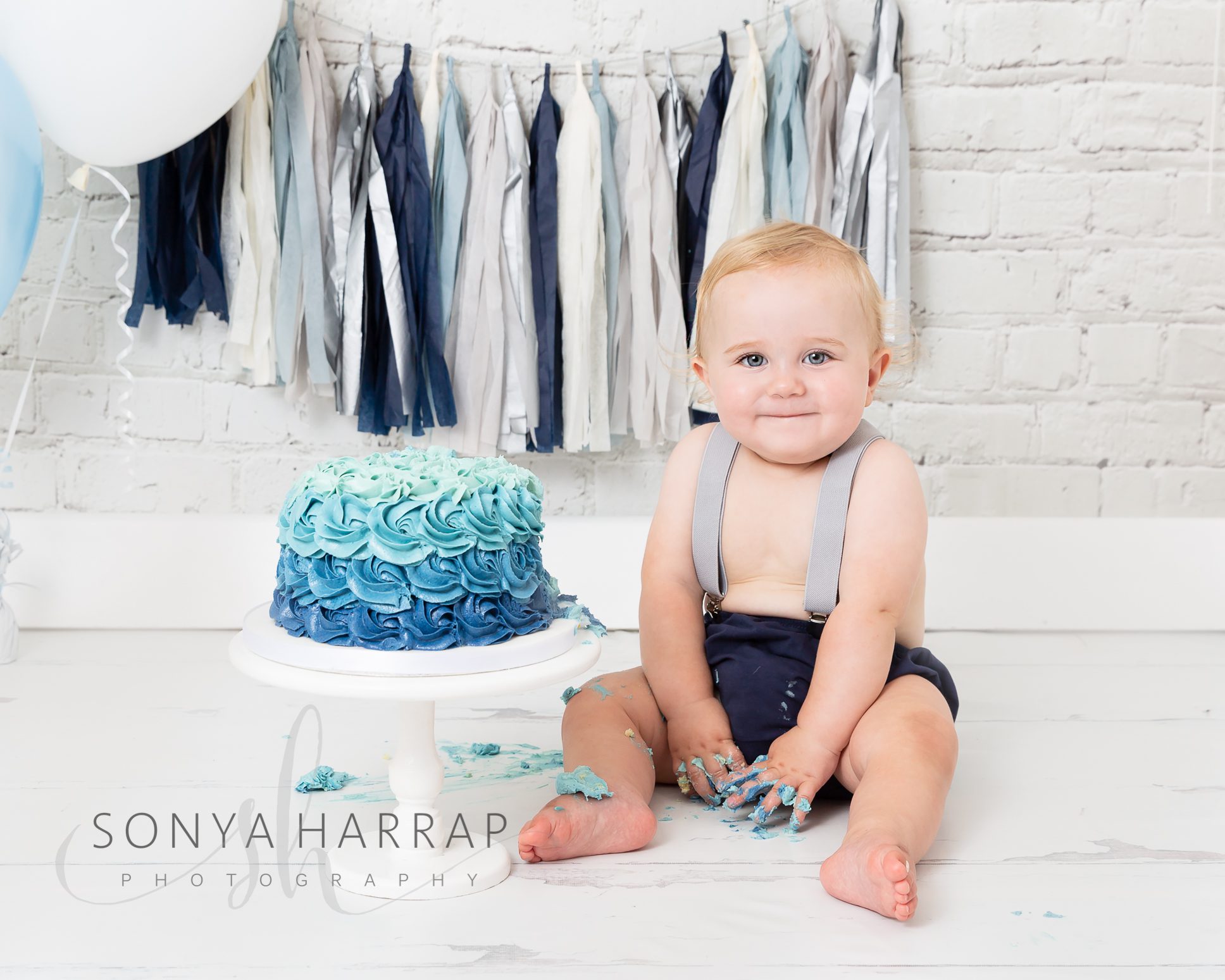 One-year-old baby enjoying their cake smash photoshoot in a Welwyn Garden City studio.